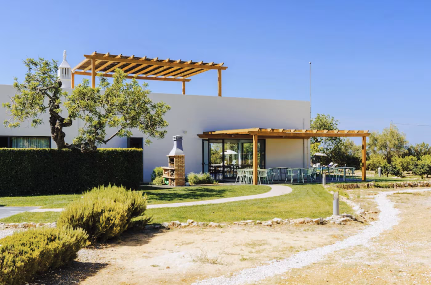 The garden terrace at Mercedes Country House with outdoor dining under a wooden pergola